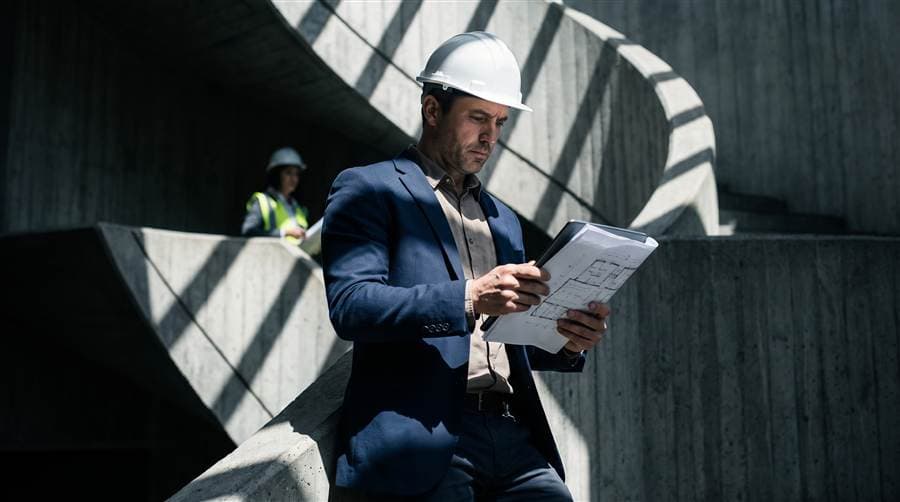 Construction project manager reviewing plans on site